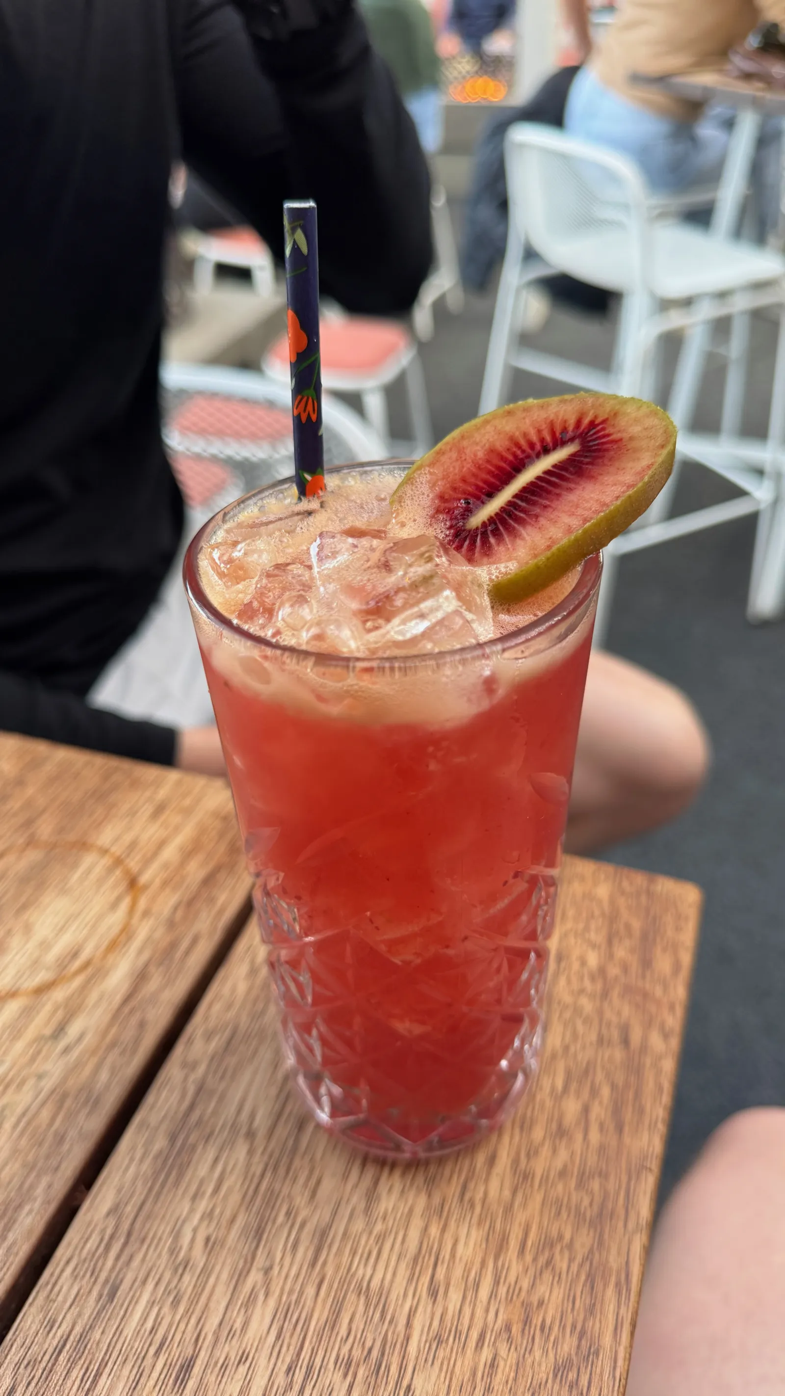 A sunset cocktail at The Sundeck, garnished with a slice of red kiwifruit.